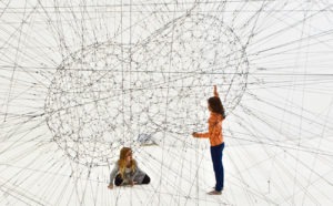 girls playing with an art installation symbolising 'networking'