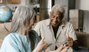 a man and women sit on a couch engaged in a cheerful conversation