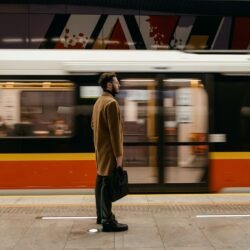a man waiting for a train with a briefcase