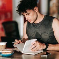 a man journalling over a cu of coffee