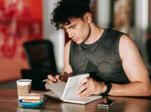 a man journalling over a cu of coffee