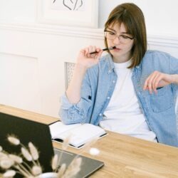 A woman at her desk contemplating and thinking