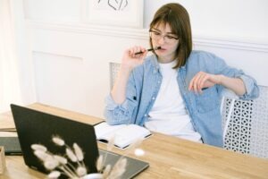 A woman at her desk contemplating and thinking