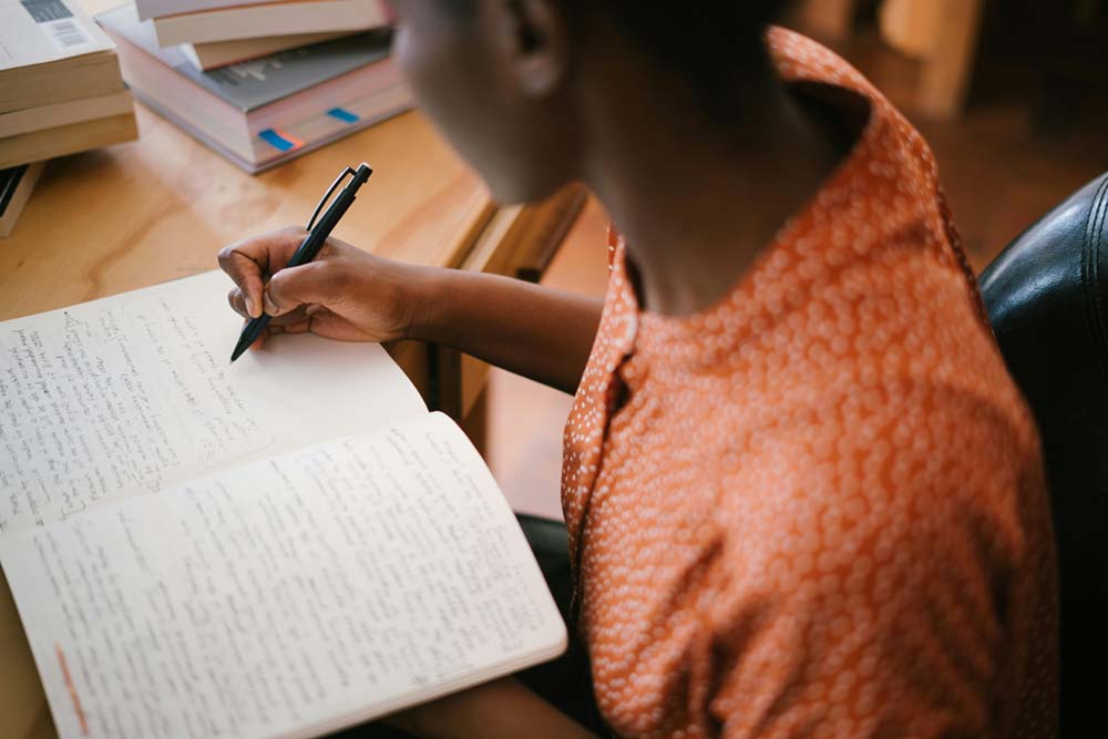 woman writing her goals down on paper